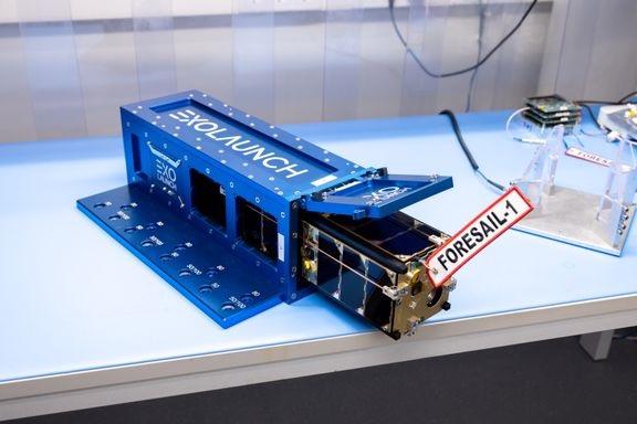 Foresail-1-satelliitti Aalto-yliopiston satelliittilaboratoriassa testaussovittimen sisällä. Samankaltaisella sovittimella satelliitti kiinnitetään Falcon 9-rakettiin.
