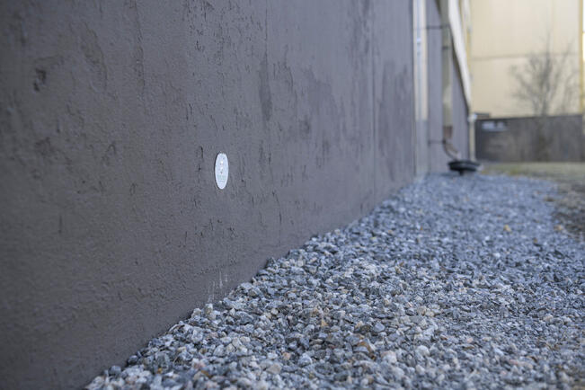 Kilpi talon sokkelissa ilmaisee maalämpökaivon paikan.