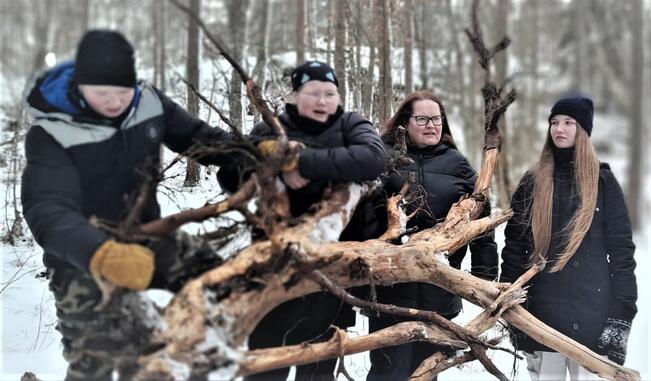 Yli-Kahrakuusen perhe voimaannuttavassa valokuvassa. Retkiruoka maistui Tuorlan nuotiopaikalla 