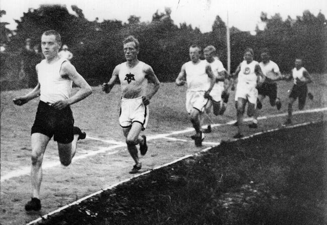 17-vuptias Paavo Nurmi tutulla paikallaan, eli kärjessä, juoksukilpailussa Turussa Urheilupuistossa vuonna 1917. Turun Sanomien kuvatekstissä puhuttiin toistaiseksi vasta "juoksijalupauksesta". 