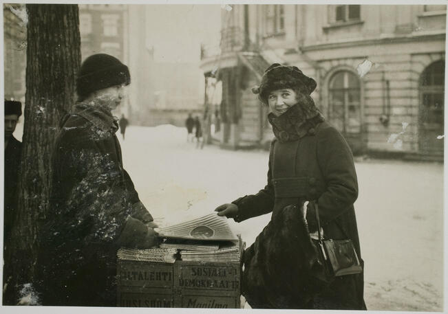 Rakastettu näyttelijä Nanny Westerlund poseeraa lehtimyyjän kanssa talvisessa 1930-luvun Helsingissä. Hän teki uskomattoman 78 vuoden uran näyttämötaiteilijana.