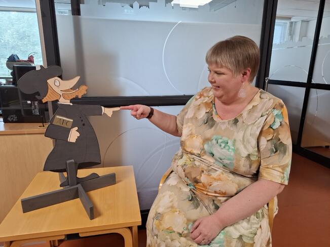 Merja Forsman pitää tärkeänä rauhallisuutta neuvottelutilanteissa, ja taustat on oltava valmiiksi selvillä. Puisen Mikael Agricola -hahmon on piirtänyt Pekka Rahkonen.