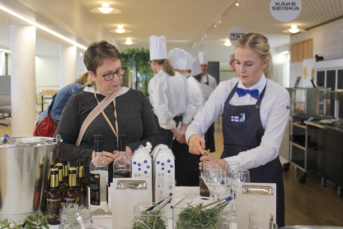 Turun kaupungin kehityspäällikkö Päivi Pohjolainen (vas.) valmisti mustikkaista Bilberry Dream -drinkkiä Roosa Urmaksen opastuksella.