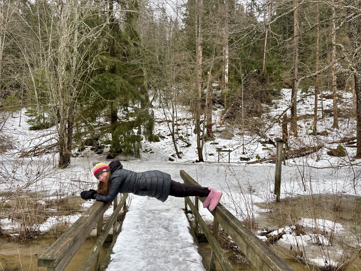 Kokonaisvaltaisen hyvinvoinnin ohjaaja Sini Tefke näyttää, miten luontovoimailussa sujuu lankutus hyödyntäen luontoympäristöä, tällä kertaa sillankaidetta.