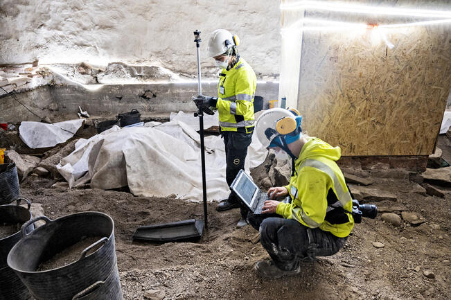 Arkeologit Lauretta Suomi (vas.), ja Marja Ronkainen dokumentoivat kirkon lattian alta löytynyttä hautaa viime kesänä. Kaivaukset aiheuttivat kuukausien katkon peruskorjaukseen.